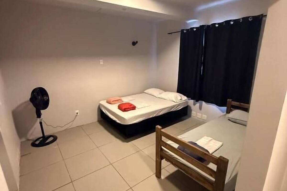 Une petite pièce, de taille modeste, comprenant un lit, une chaise et un bureau.