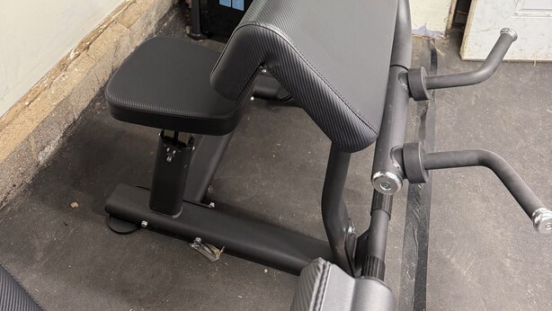 Une salle de sport équipée d’une machine de musculation, d’un miroir et d’une porte.