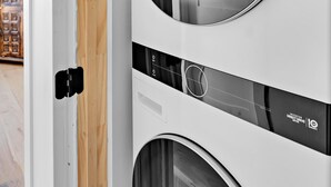 Une machine à laver blanche, dotée d’une porte ronde et d’un panneau de commande.