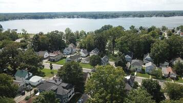 Un barrio residencial con casas, una carretera y un lago al fondo.