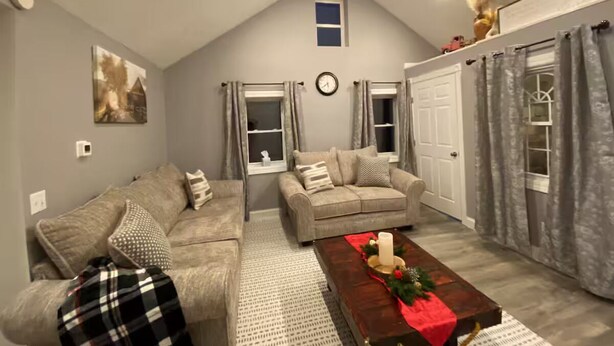 A living room with two sofas, a coffee table, and a clock on the wall. - Buckeye Cottage (Willard)