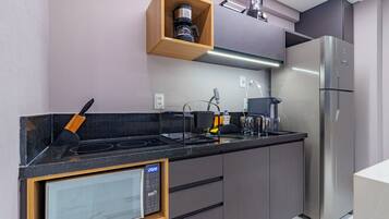 A modern kitchen with a built-in microwave, stove, and stainless steel refrigerator.