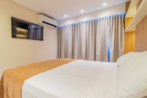A hotel room with a bed, a wall-mounted air conditioner, a mirror, and a curtain with blue LED lights. - Homes Stay #2306 - Ideal Location in Carpediem (Recife)