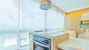 Una cocina moderna con horno empotrado, un ventanal con vistas a la ciudad y un diseño minimalista.