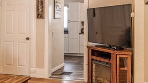 Ein Wohnzimmer mit einer Holz-Unterhaltungsanlage, einem Flachbildfernseher und einem Kamin.