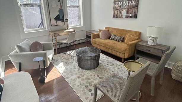 Un salon moderne comprenant un canapé, des fauteuils, une table basse et un coin repas.