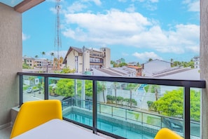 A balcony with a view of a swimming pool, a building with a balcony, and a clear sky. - Villa Del Mar #102 - Flat in Ipojuca by Carpediem (Ipojuca)