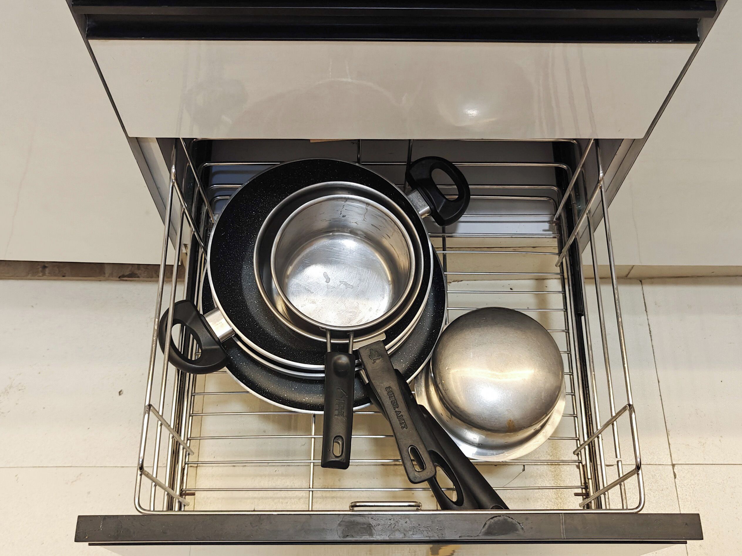Un cajón de cocina con ollas y sartenes.
