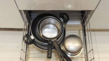 Un cajón de cocina con ollas y sartenes.