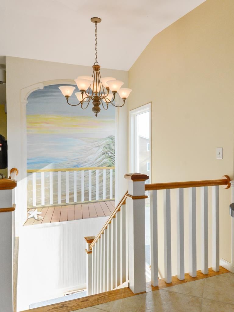 A staircase with a white railing and a chandelier.
