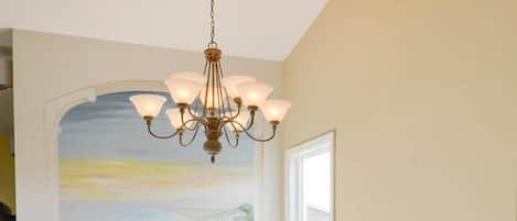 A staircase with a white railing and a chandelier.