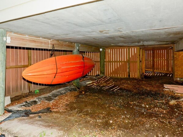 A room with a concrete ceiling, a wooden door, and a large orange object hanging from the ceiling. - 4BR House w/ Deck | Close to Beach! (South Bethany Beach)