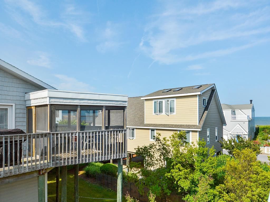 A residential property with a covered patio, a detached garage, and a well-maintained lawn.