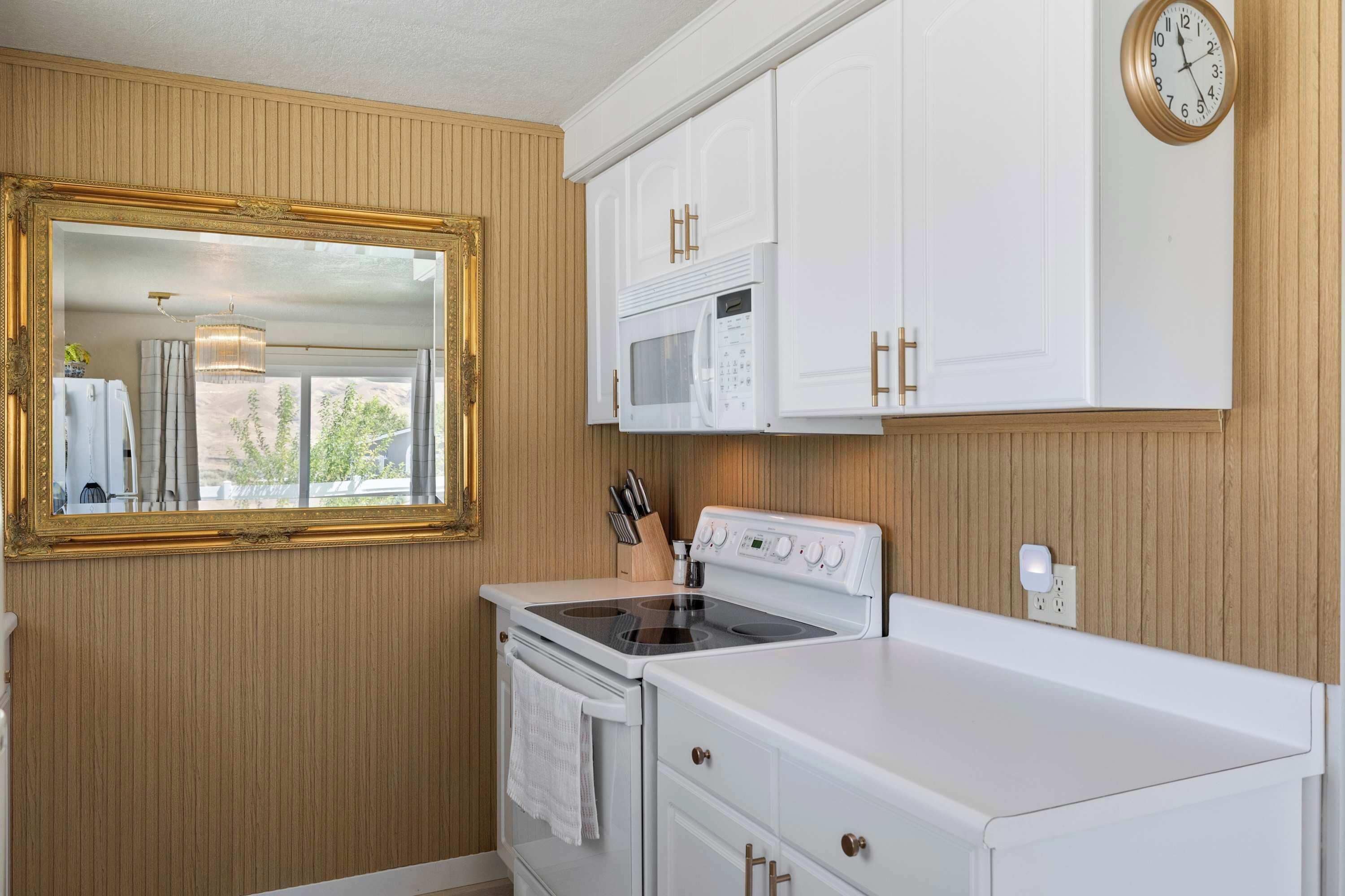 A kitchen with a stove, microwave, and cabinets.
