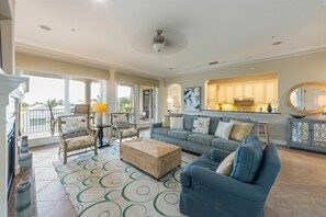 A spacious living room with a sofa, chairs, a coffee table, and a kitchen area in the background. - Direct Beach Access Beautiful Resort Balcony (Holmes Beach)