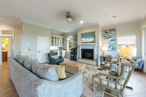 A spacious living room with a fireplace, a dining area, and a kitchen. - Direct Beach Access Beautiful Resort Balcony (Holmes Beach)