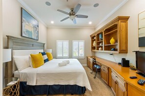 A bedroom with a bed, a desk, a chair, a ceiling fan, and a TV. - Direct Beach Access Beautiful Resort Balcony (Holmes Beach)