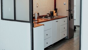 Eine moderne Küche mit Holzarbeitsplatte, integriertem Herd und Kühlschrank.