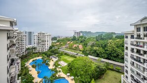 A high-rise residential building with multiple balconies, a swimming pool complex, and lush greenery. - 5 Bedroom Penthouse Ocean Views Jacobay 21002 (Jaco)