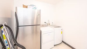 A compact kitchen with a stainless steel refrigerator and a built-in washer and dryer. - 7 Bedroom Penthouse Ocean & Mountain Views JB31001 (Jaco)