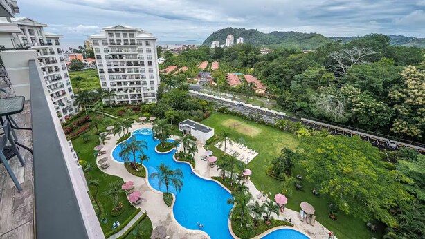 A hotel with a large pool area, lush greenery, and a view of surrounding buildings. - 7 Bedroom Penthouse Ocean & Mountain Views JB31001 (Jaco)