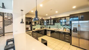 A modern kitchen with black cabinets, stainless steel appliances, and a checkered backsplash. - 7 Bedroom Penthouse Ocean & Mountain Views JB31002 (Jaco)