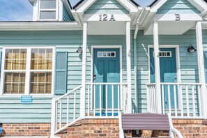 A two-story building with numbered doors labeled 12A and 12B, a private parking sign, and a brick foundation. - Anchors Away Two Blocks to Surfside Beach. (Surfside Beach)