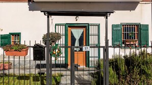 A building with a number 27 sign, green shutters, and a small porch with a metal railing. - Casa Olinda, which opens to Mount Emilius and the Gran Paradiso massif. (Saint-Christopher)