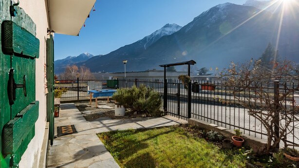 A patio with a view of mountains, a pool, and a fenced area with potted plants. - Casa Olinda, which opens to Mount Emilius and the Gran Paradiso massif. (Saint-Christopher)