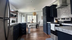 Eine moderne Küche mit dunklen Schränken, Edelstahlgeräten und Holzboden.