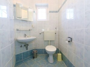 Ein Badezimmer mit Waschbecken, Toilette und Spiegel.