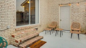 A brick exterior with a white door, a window, and a welcome mat. - 3BD Townhome w/ Patio, 3 Mi to Fort Bragg/Liberty (Fayetteville)