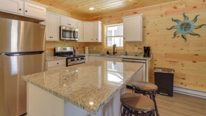 A kitchen with a granite countertop, stainless steel appliances, white cabinets, and a wooden ceiling. - Retreat Near Ice Fishing, ATV Trails, Golf, Skiing (Danbury)