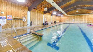 An indoor swimming pool with wooden walls, a lifeguard station, and a pool ladder. - Retreat Near Ice Fishing, ATV Trails, Golf, Skiing (Danbury)