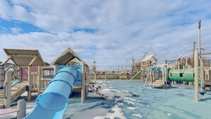 A playground with a blue slide, climbing structures, and a covered seating area. - Walk to Shore! Family Haven w/ Pool in Ocean City (Ocean City)