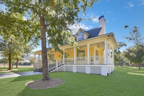 A two-story house with a covered porch, a chimney, and a well-maintained lawn. - All-in-one Luxury Escape Three Properties, Event Hosting, Private Pond & Full Gym (Jacksonville)