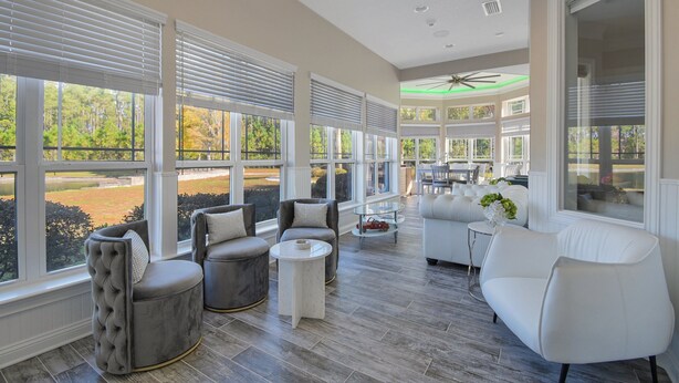 A spacious indoor area with large windows, a ceiling fan, and a mix of seating options including sofas and armchairs. - All-in-one Luxury Escape Three Properties, Event Hosting, Private Pond & Full Gym (Jacksonville)