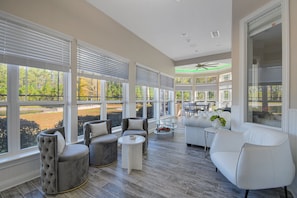 A spacious indoor area with large windows, a ceiling fan, and a mix of seating options including sofas and armchairs. - All-in-one Luxury Escape Three Properties, Event Hosting, Private Pond & Full Gym (Jacksonville)