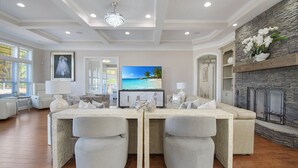 A spacious living room with a large TV, a fireplace, and a stone accent wall. - All-in-one Luxury Escape Three Properties, Event Hosting, Private Pond & Full Gym (Jacksonville)