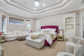 A bedroom with a large bed, a white sofa, a white armchair, and a small table with a lamp. - All-in-one Luxury Escape Three Properties, Event Hosting, Private Pond & Full Gym (Jacksonville)