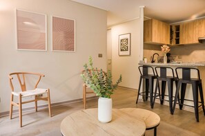 Eine moderne Küche mit Holdekor, einer schwarzen Arbeitsplatte und einer Bar mit Hockern.