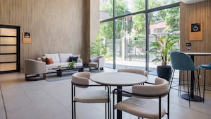 Un interno moderno con un divano, poltrone, un tavolo rotondo e un angolo caffè.