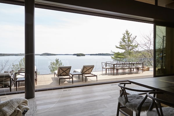 A modern outdoor deck with a view of a lake and distant islands.