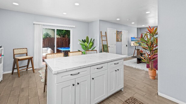 A spacious kitchen with a large island, white cabinetry, and a view to a backyard. - Boho Vibrant San Diego House w/Patio, Grill & Games (San Diego)