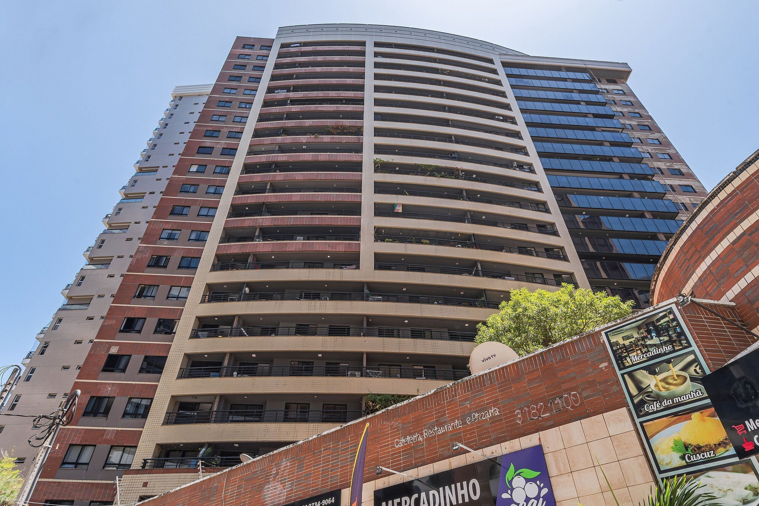Un grand immeuble à plusieurs étages, doté d’une façade incurvée, de balcons et de grandes fenêtres.
