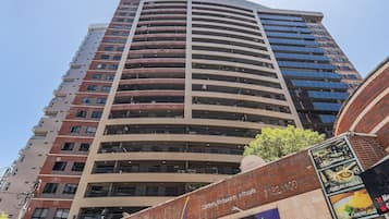 Un grand immeuble à plusieurs étages, doté d’une façade incurvée, de balcons et de grandes fenêtres.