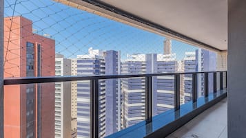 Un balcon doté d’une balustrade en métal, d’où l’on peut admirer une vue sur la ville, avec ses nombreux immeubles.