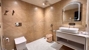 Uma casa de banho moderna com sanita, lavatório e chuveiro.
