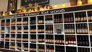 Een wijnrek bij Georgetown Winery, met een bord waarop staat dat de wijnmakerij in 2006 is opgericht.