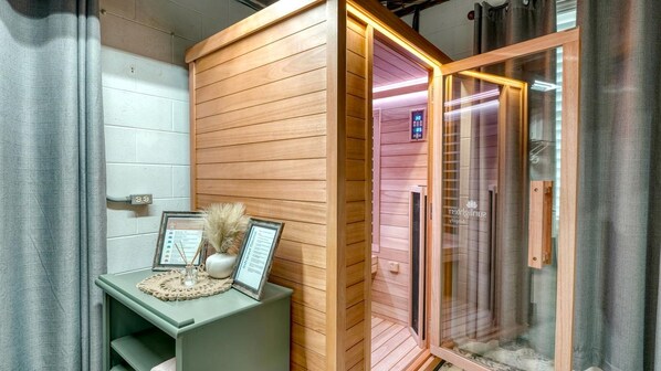 Un sauna avec un banc en bois, un certificat encadré et un petit vase contenant des plantes séchées.